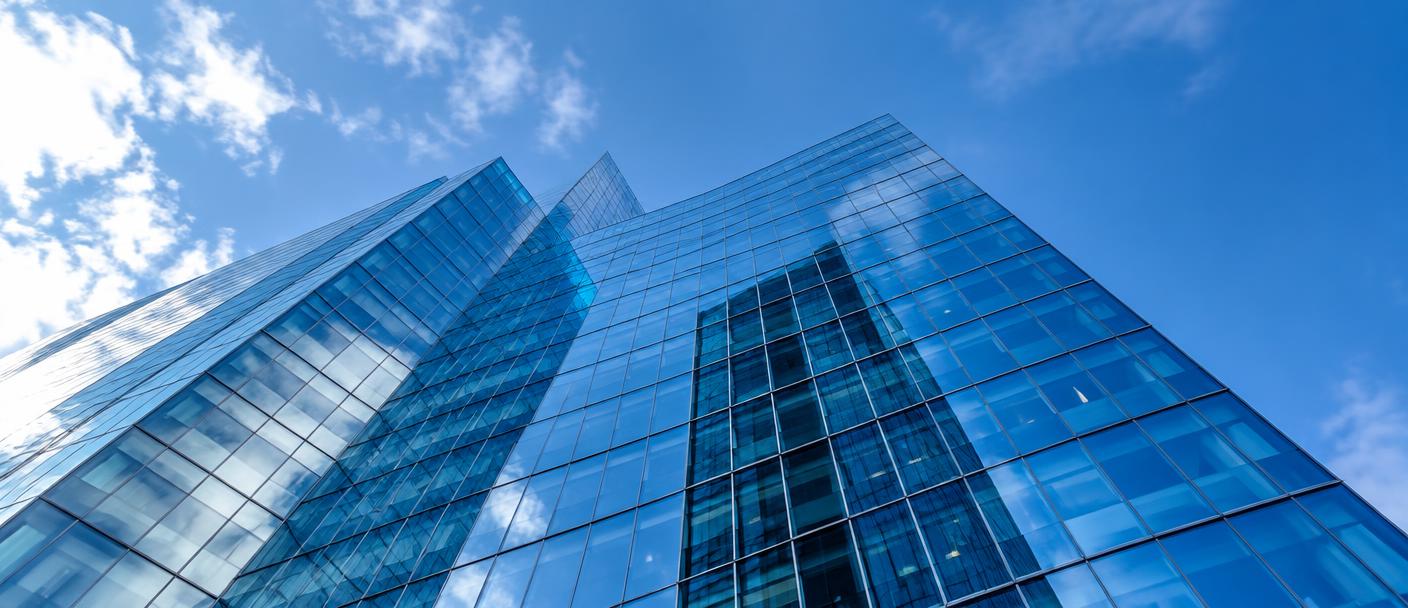 Glass office building against a blue sky